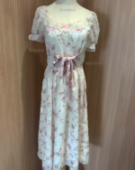 Pink cottagecore dress featuring floral print, lace details, and a tie waist.