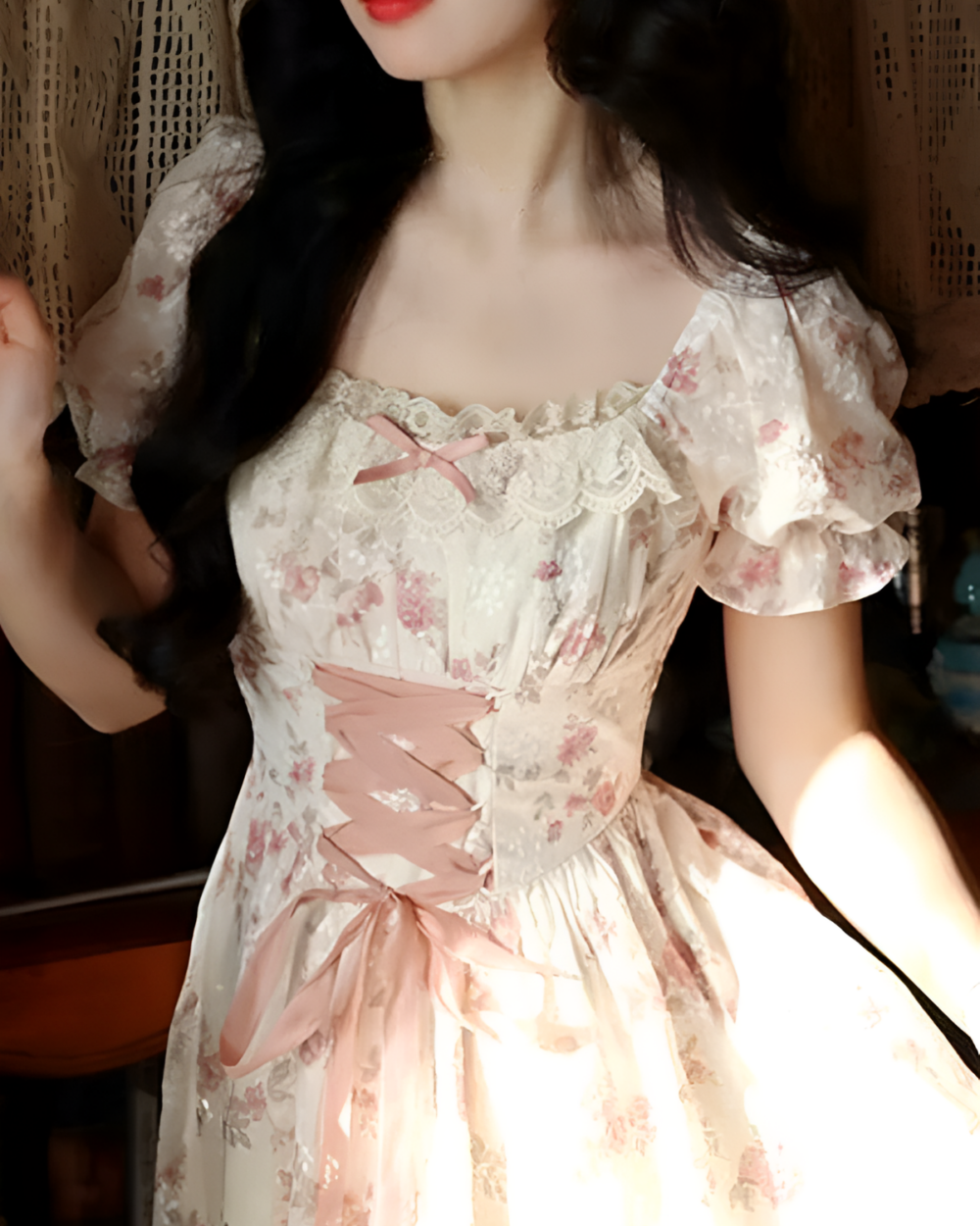 Close-up of a pink cottagecore dress with floral print, lace, and ribbon details.