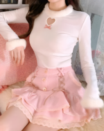 Pink mini skirt with lace and ruffles, featuring a heart detail and button closure.