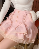 Close-up of a pink mini skirt with lace and ruffled details, featuring button closures.