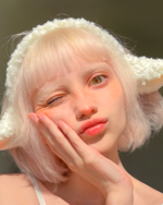 Close-up of a person wearing a fluffy white lamb ears headband. The headband features soft, curled lamb ears.