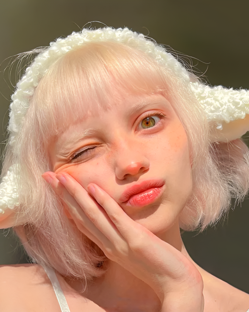 Close-up of a person wearing a fluffy white lamb ears headband. The headband features soft, curled lamb ears.