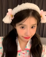 Woman wearing a fluffy white lamb ears headband with pink bows and bells. This is a cute lamb ears headband accessory.