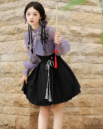 Model wearing a lavender Qi Lolita outfit, featuring a blouse and pleated skirt with tassels.