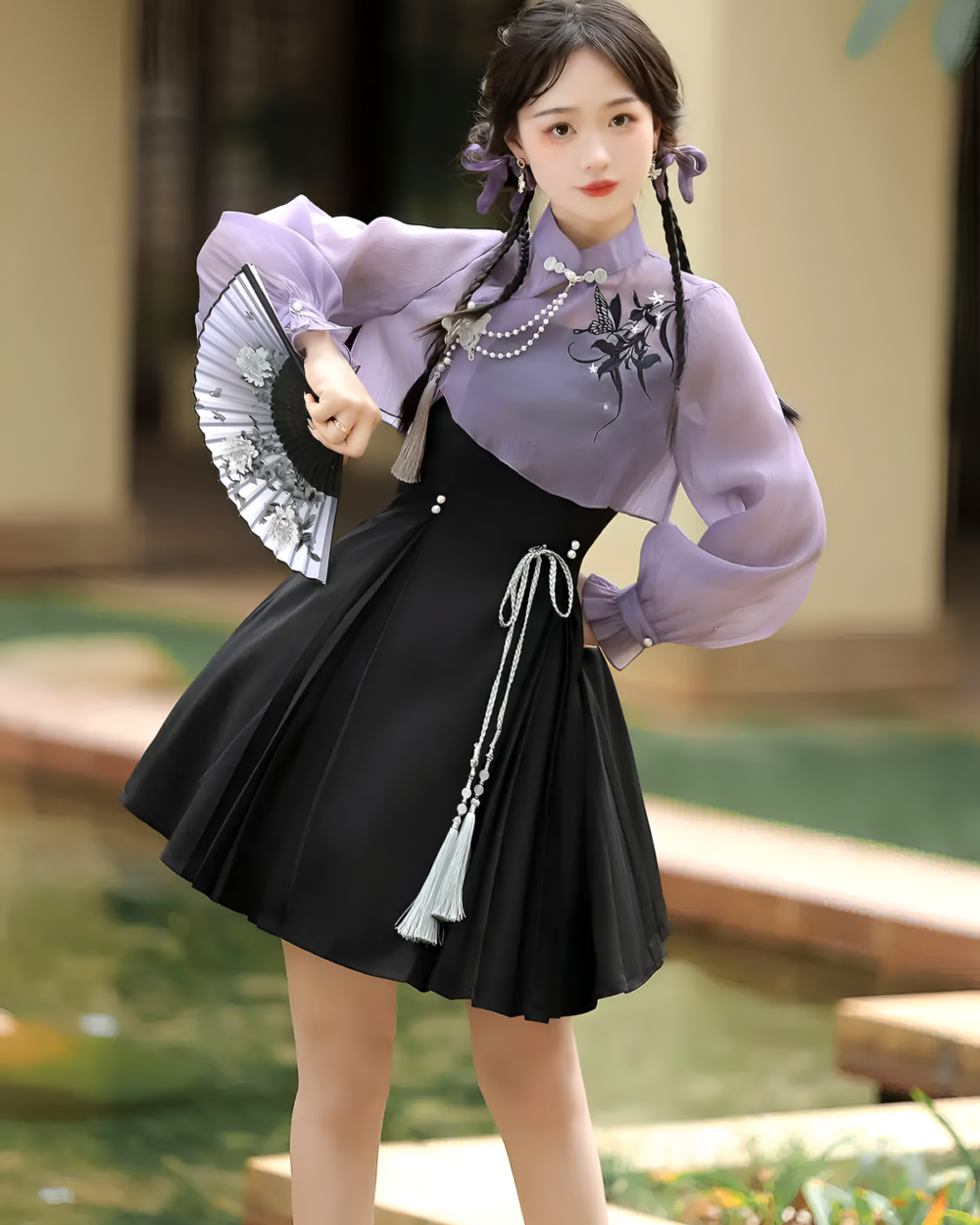 A woman wearing a Lavender Set - Qi Lolita outfit, featuring a purple blouse, skirt, and fan.