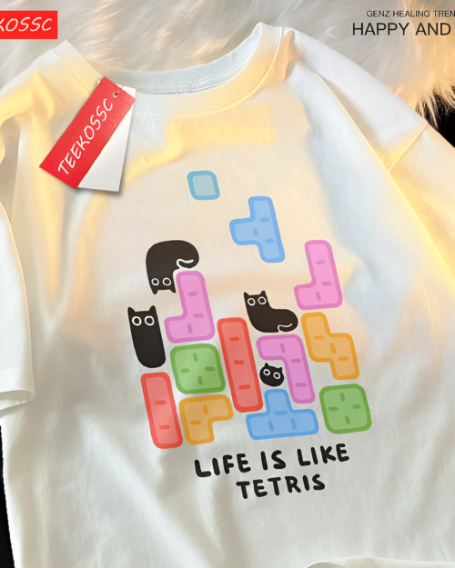 White t-shirt with a graphic of Tetris blocks and black cats. Features a "Life is Like Tetris" text and a Kuro Neko T-Shirt design.