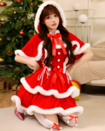 Girl wearing a Little Red Riding Hood Dress with white fur trim in front of a Christmas tree. Red hooded cape dress.
