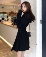 Woman wearing a black Acubi aesthetic dress with a tie waist detail.