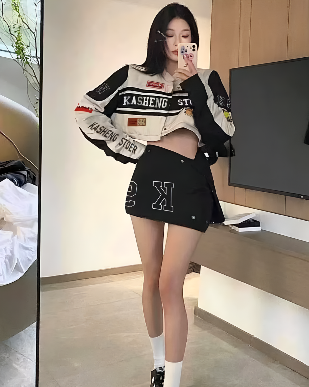 A Long Sleeve Racing Cardigan worn by a person, featuring a design with text and logos.