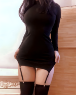 Black coquette mini dress featuring a long sleeve and suspender straps.