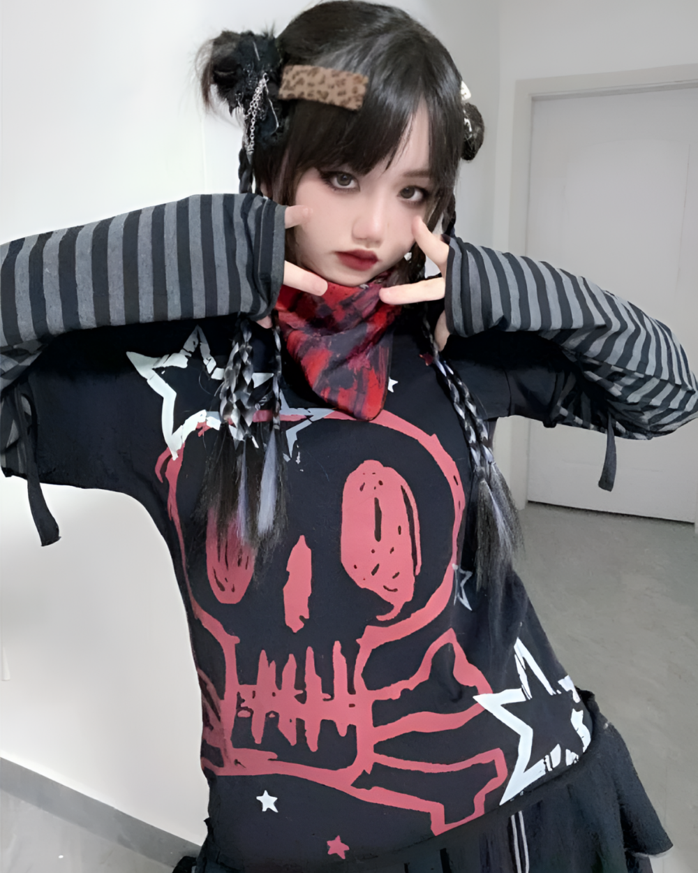 Black skull print shirt with long striped sleeves, featuring a detailed skull design.