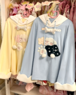 Two Jojifuku hoodies hanging in a closet, one yellow and one blue, both with bear embellishments.