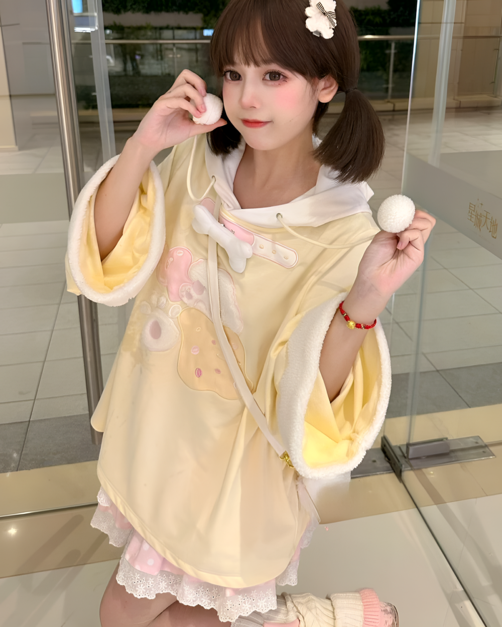 Woman wearing a yellow jojifuku hoodie with bear ears and a fluffy hood.