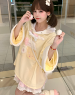 Woman wearing a yellow jojifuku hoodie with bear ears and a fluffy hood.