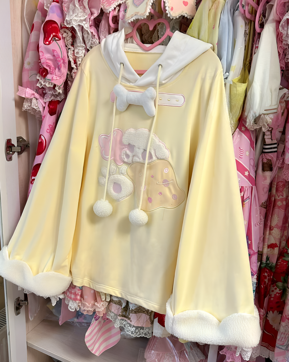 Jojifuku hoodie, a pale yellow hooded sweatshirt with plush bear decorations and fluffy cuffs.