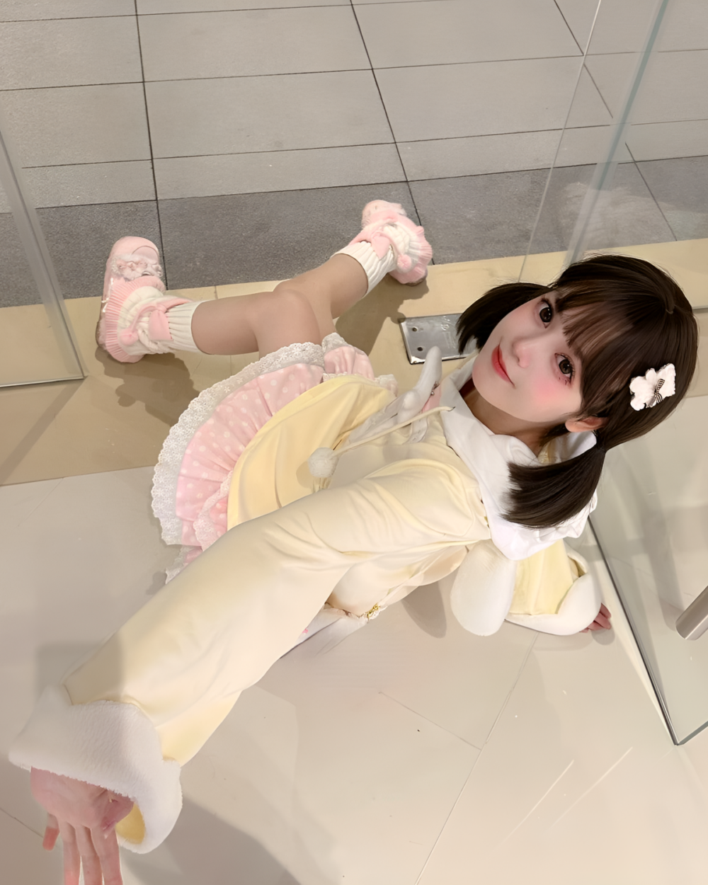 Jojifuku hoodie worn by a person in a retail setting, featuring a yellow long-sleeve top and layered accessories.