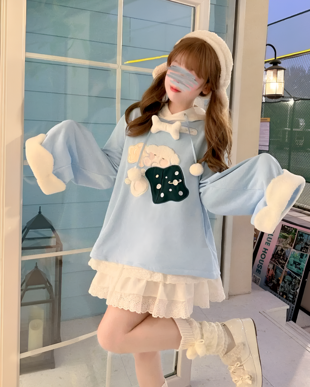 Model wearing a blue jojifuku hoodie with a fluffy hood and cute bear print.