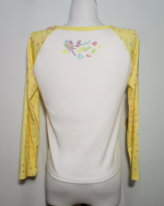 Back view of a yellow Mezzo Piano cake T-shirt with long sleeves, featuring a colorful graphic print and contrasting white underlayer.
