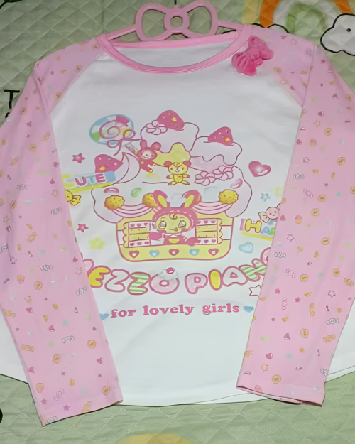 Pink long sleeve Mezzo Piano cake T-shirt for girls with a cake and character graphic. Featuring a crew neck and pink trim.