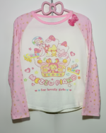 Pink long sleeve Mezzo Piano cake T-shirt with a cute graphic print, hanging on a pink hanger.