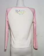 Back view of a Mezzo Piano cake T-shirt, long sleeve, pink and white with colorful graphic details.