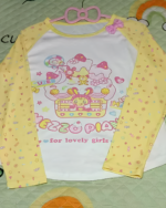 Mezzo Piano cake T-shirt with a yellow and white color scheme, featuring a cake and star pattern.