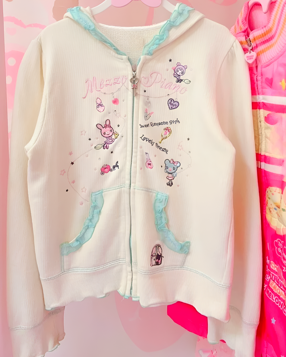 Close-up of a Mezzo Piano pink hoodie with Yume Kawaii aesthetic. Features embroidery and lace details.