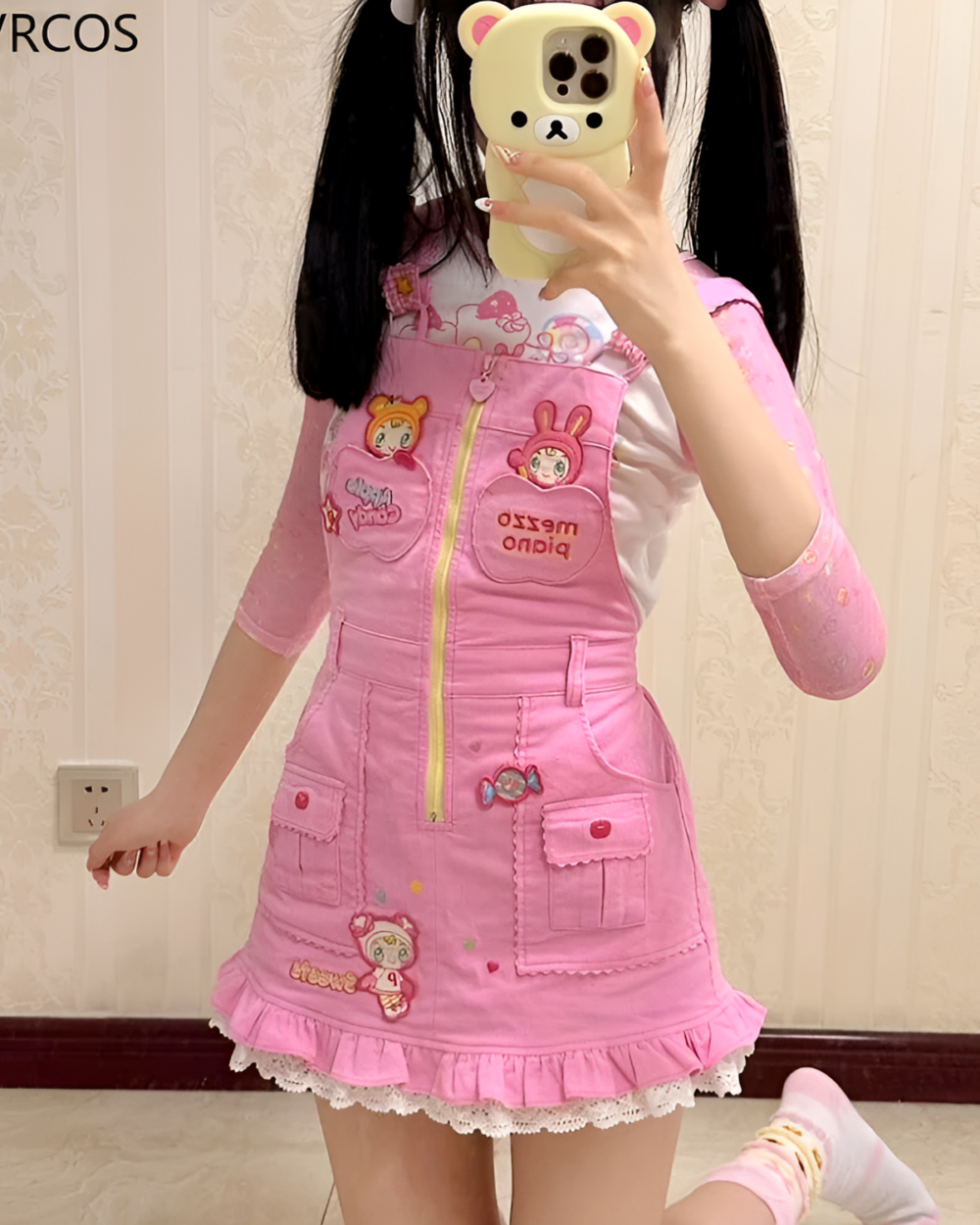 A girl wearing a pink Mezzo Piano dress with cartoon bear and bunny patches. Jojifuku aesthetic style.