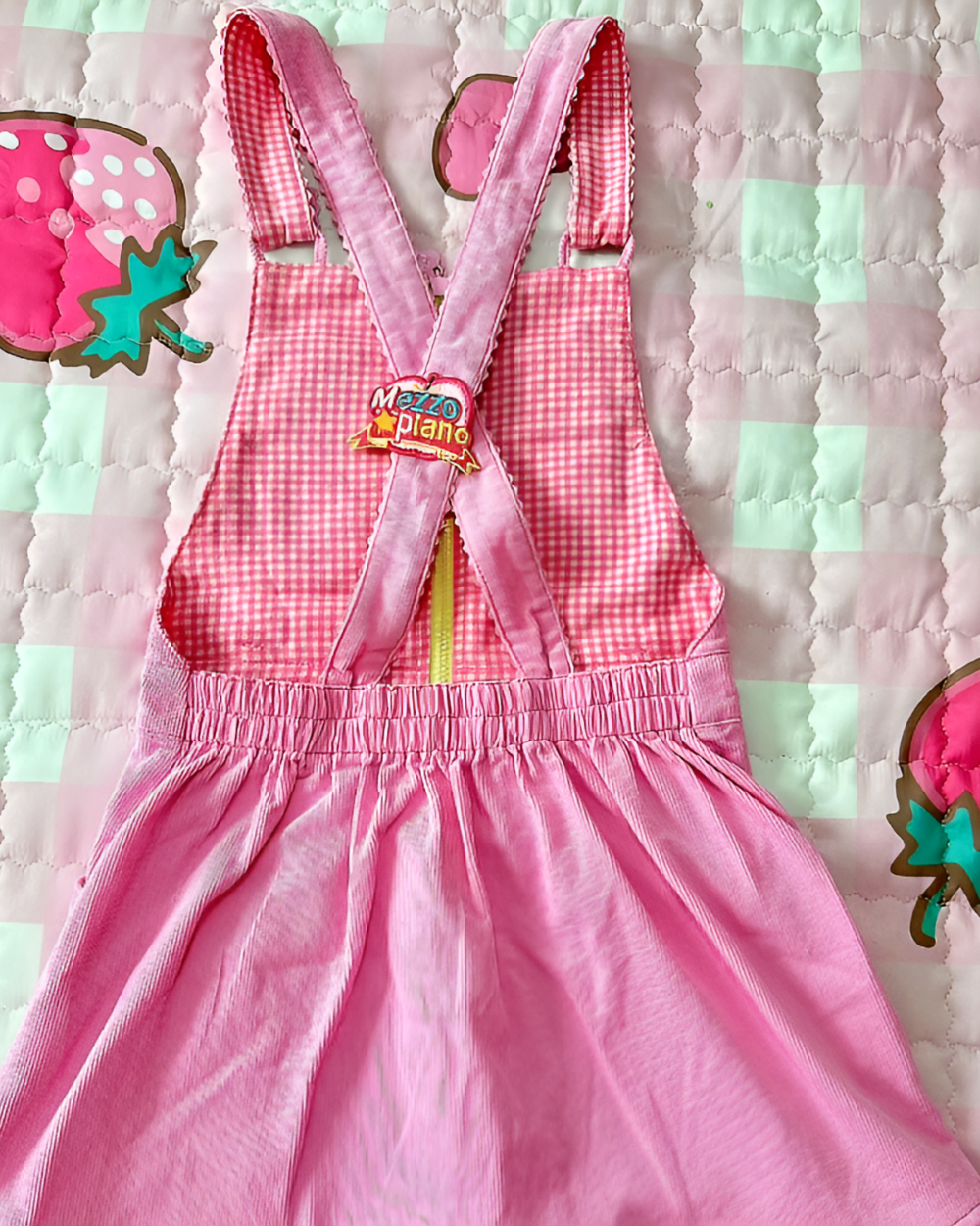 Pink and white gingham Mezzo Piano dress with strawberry embroidery. Features adjustable straps and a flared skirt.