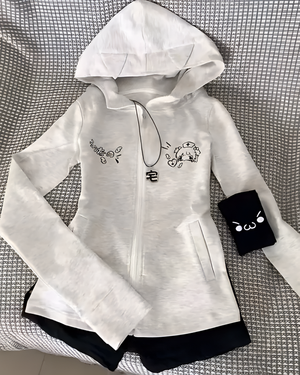 White zip-up hoodie with black accents and cat ears. Features a Yami Kawaii hoodie design with graphic prints.