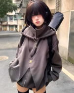 Woman wearing a gray oversized Moonlight Zipper Hoodie on the street. The hoodie features a star detail and a zippered front.