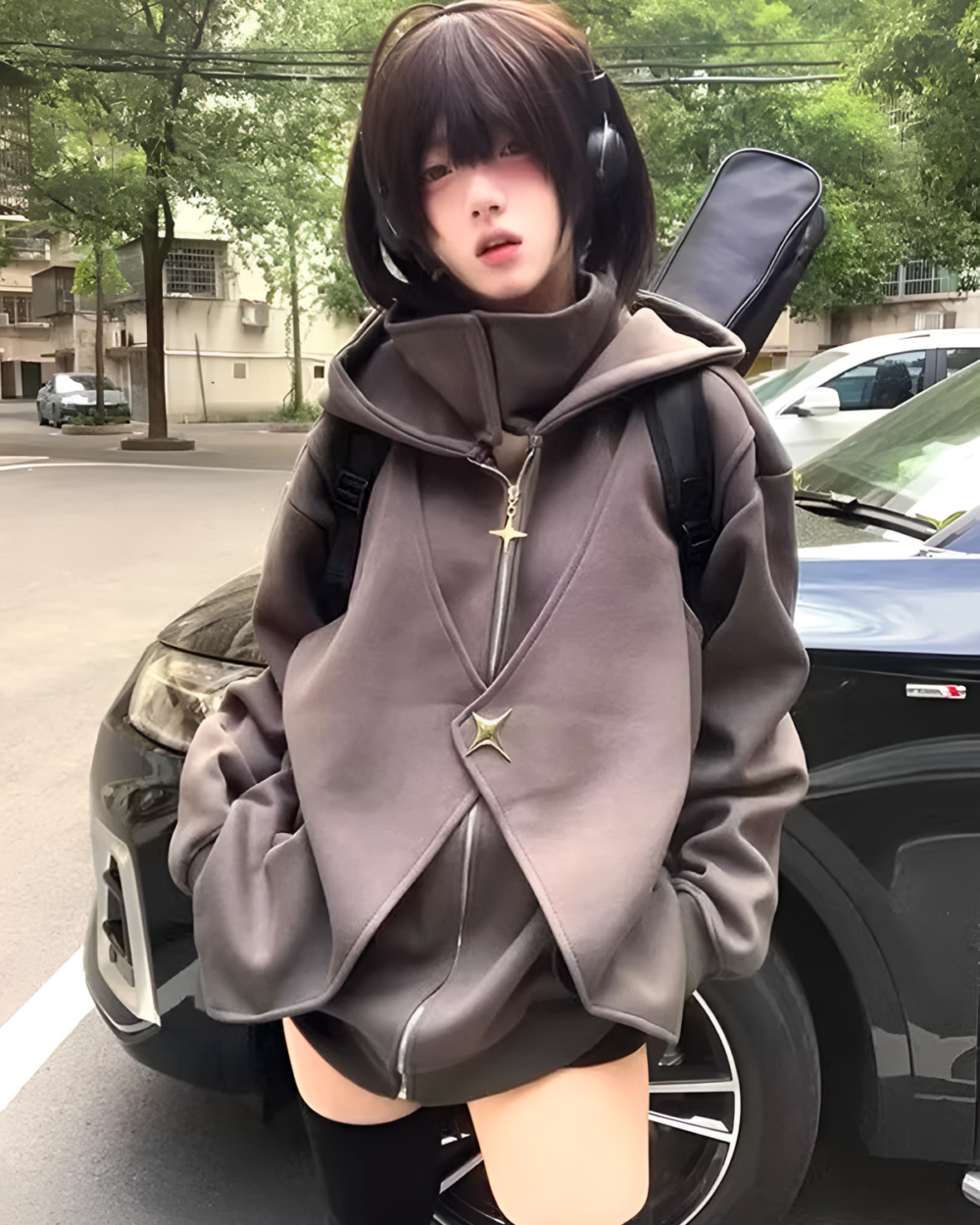 Woman wearing a gray Moonlight Zipper Hoodie outdoors with headphones and carrying a guitar case.