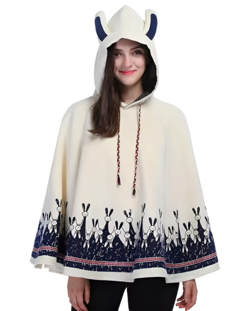 Woman wearing a cream-colored bunny fleece cape with a bunny print along the hem and hood. The cape features drawstring ties.