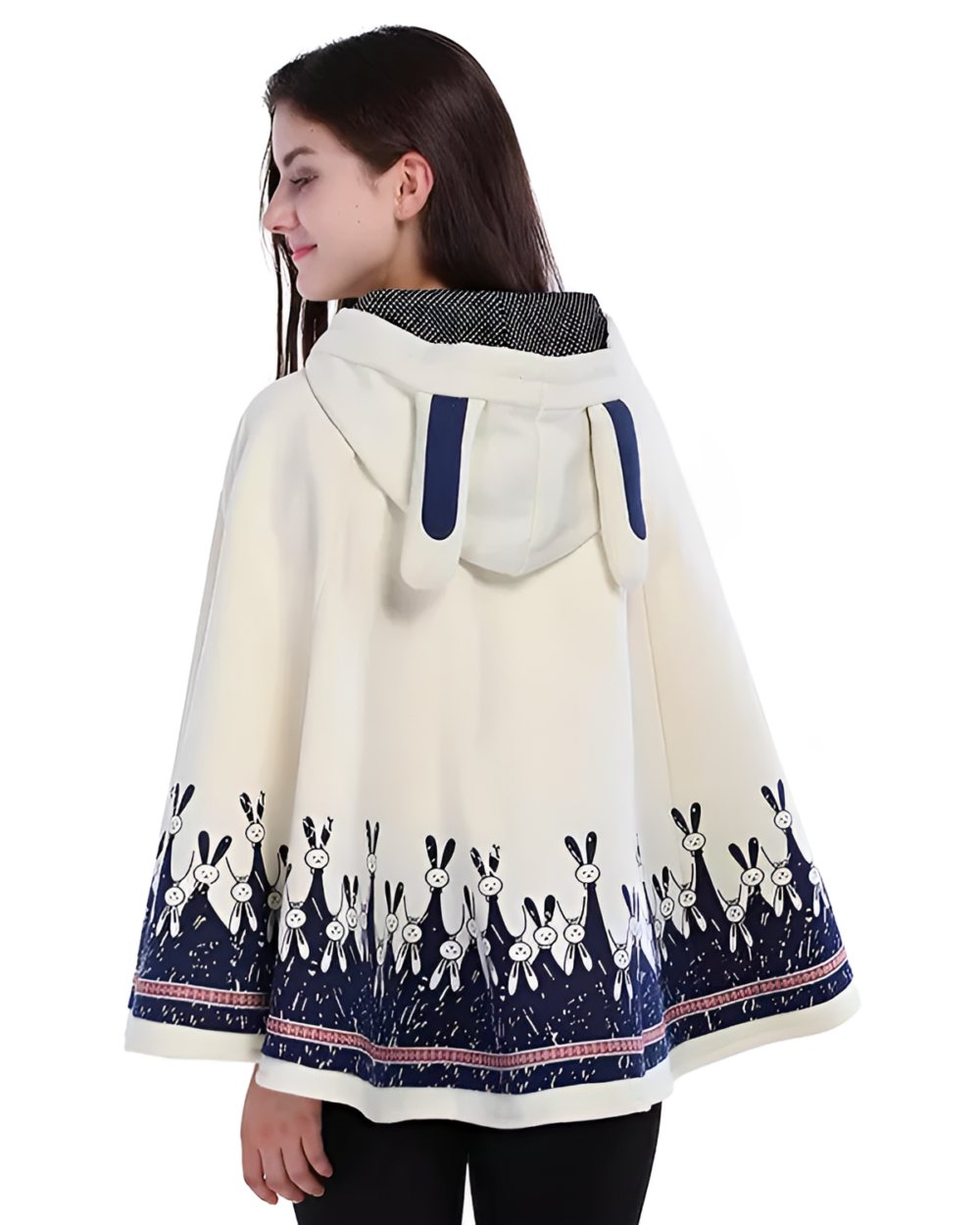 Woman wearing a white Moonlit Bunny Fleece Cape with blue bunny details. A cozy bunny fleece cape with a hood and patterned hem.