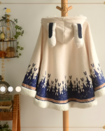 Cream and navy blue bunny fleece cape with a hood, featuring a rabbit pattern and decorative trim.