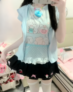 A person wearing a light blue Necolon T-Shirt featuring a Yume Kawaii aesthetic print with cute animals.