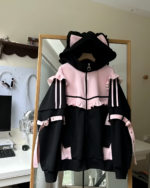 Neko Frill Zip Hoodie in black and pink, featuring cat ears and a heart detail, displayed on a hanger.