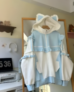 Pastel blue and white Neko Frill Zip Hoodie hanging on a hanger. Features a cat-ear hood and frills.