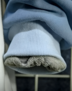 Close-up of the ribbed cuffs of a light blue Neko Sensei Pullover Hoodie, showing fabric texture.