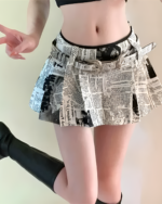 Woman wearing a newspaper print Y2K pleated skirt with a high waist and short length.