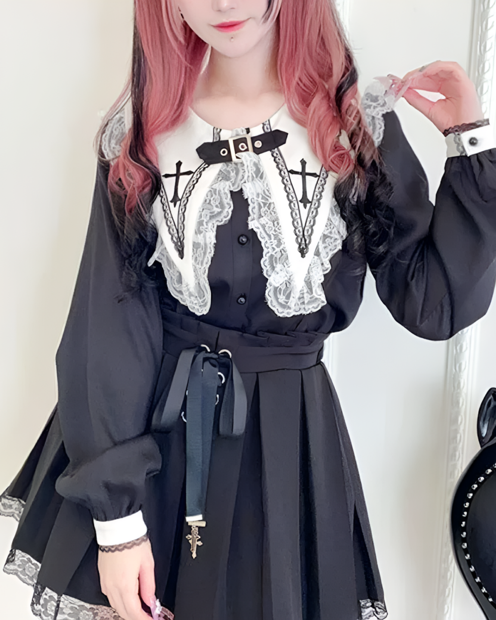 Model wearing a black Nocturne Cross-Collar Jirai Kei blouse with lace details and long sleeves. Features a cross pendant and waist tie.