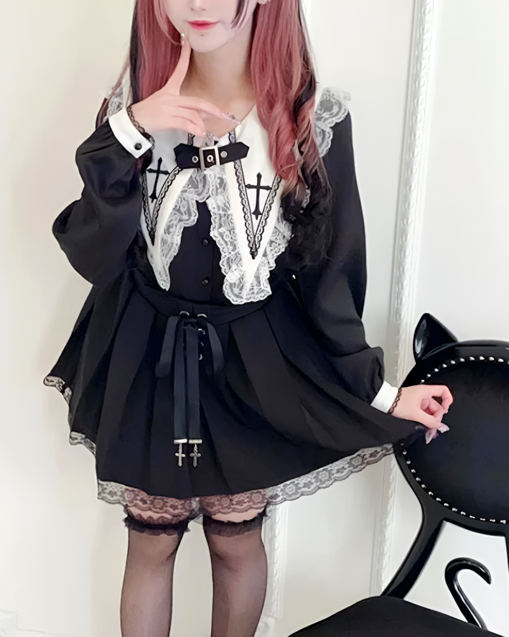 Model wearing a black Jirai Kei blouse with white lace details and a cross-collar. Features long, puffy sleeves and a fitted waist.