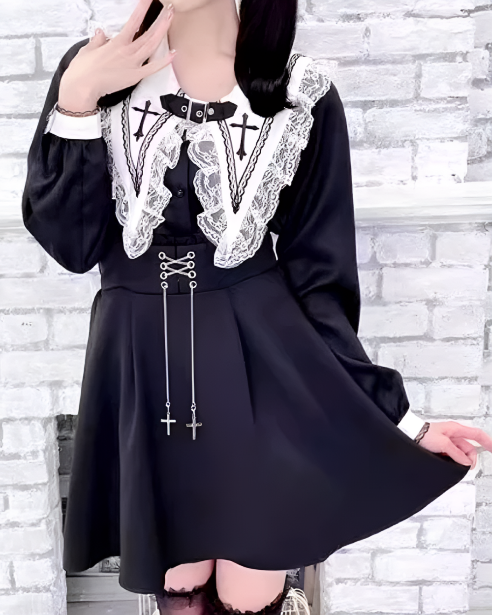 Black Jirai Kei blouse with lace and cross details. Long sleeves and flared skirt. Features a collar and ribbon ties.