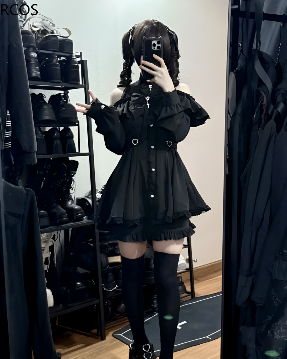 Model wearing a black Noir Heart Ruffle Cold-Shoulder Coord, a Gothic Lolita coord with ruffle details and cold-shoulder design.