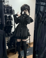 Model wearing a black Noir Heart Ruffle Cold-Shoulder coord. This Gothic Lolita coord features a ruffle-detailed dress and thigh-highs.