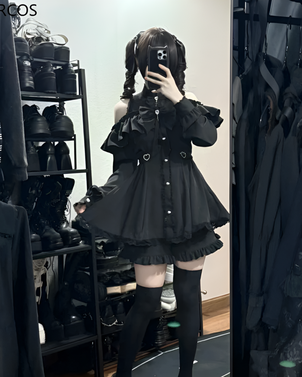 Model showcasing the Noir Heart Ruffle Cold-Shoulder Coord, a black Gothic Lolita coord with ruffle and cold-shoulder details.