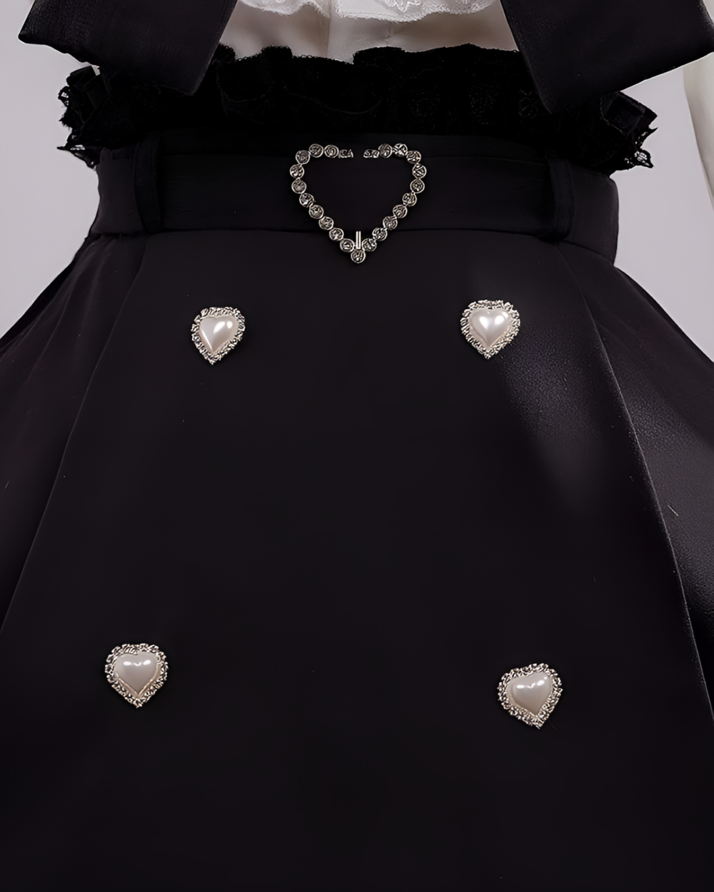 Close-up of Noir Pearl Pinafore Coord details, showcasing pearl buttons and heart accents. Reflects a distinct Jirai Kei aesthetic.