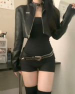 Woman wearing a black Noir Shadow Crop Moto Jacket, an e-girl crop jacket. The jacket has a silver zipper and a fitted silhouette.