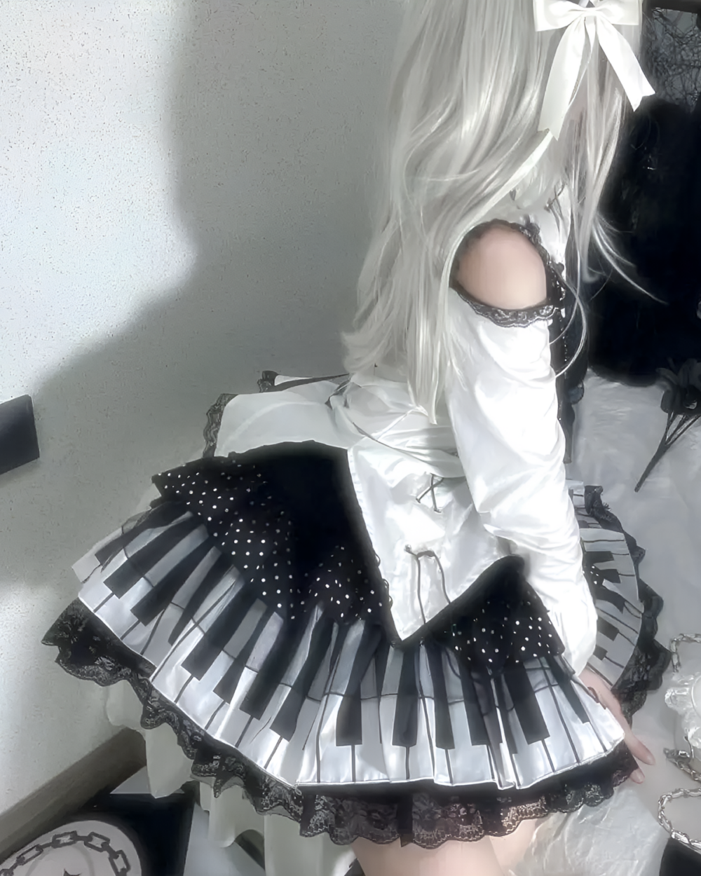 Noir Sonata Skirt product photo 1 Model wearing the Noir Sonata Skirt, a black and white piano key skirt. Features a high-waisted, pleated design.