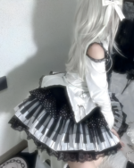 Model wearing the Noir Sonata Skirt, a black and white piano key skirt. Features a high-waisted, pleated design.